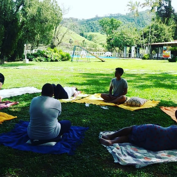 Alunos praticando meditação em um ambiente natural durante o curso.